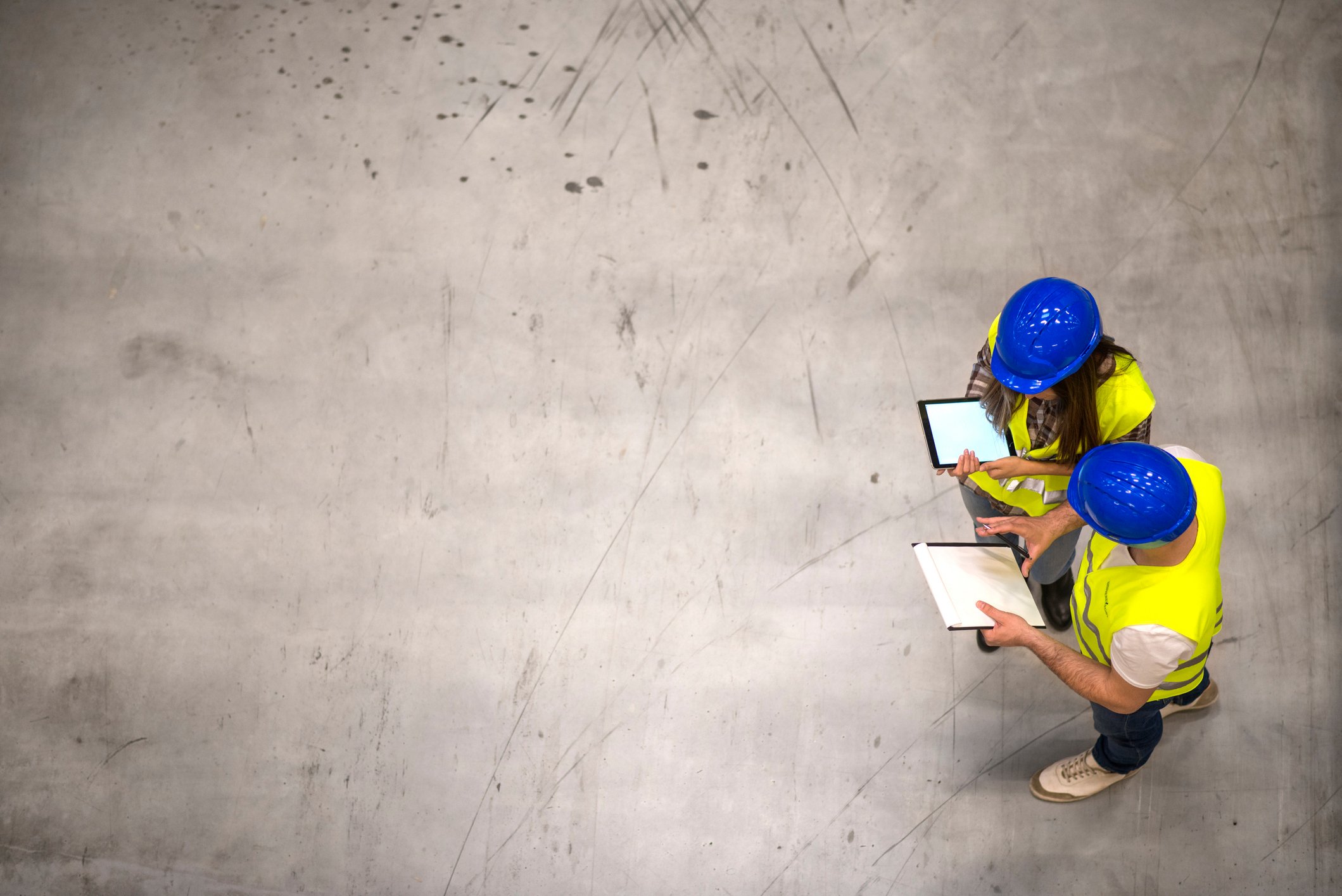 Two workers using tablets in a warehouse.