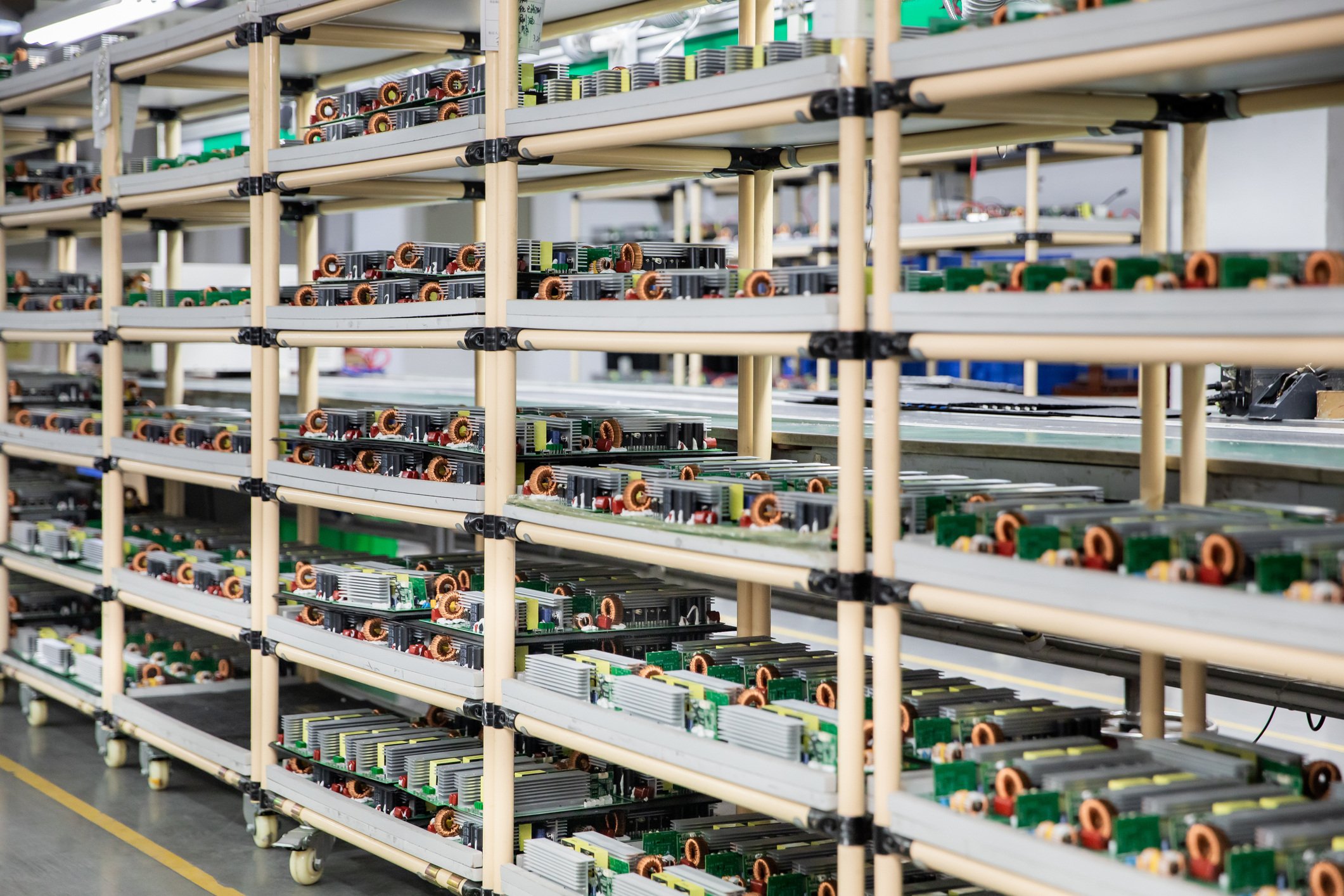 Production factory with printed circuit boards and batteries on shelves.