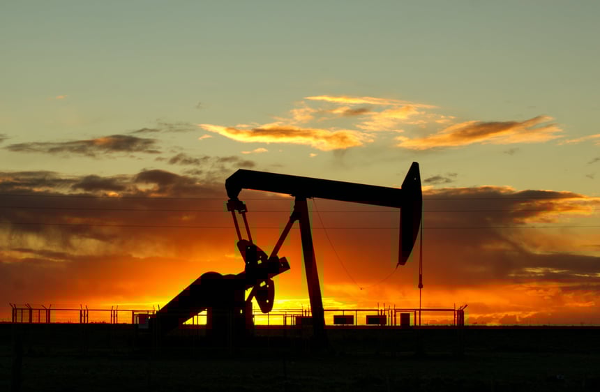 Silhouette of a piece of mining equipment with the sun setting in the background.